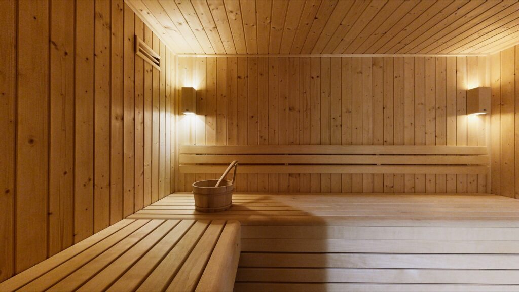 Le sauna du chalet, banquettes en bois et lumière douce