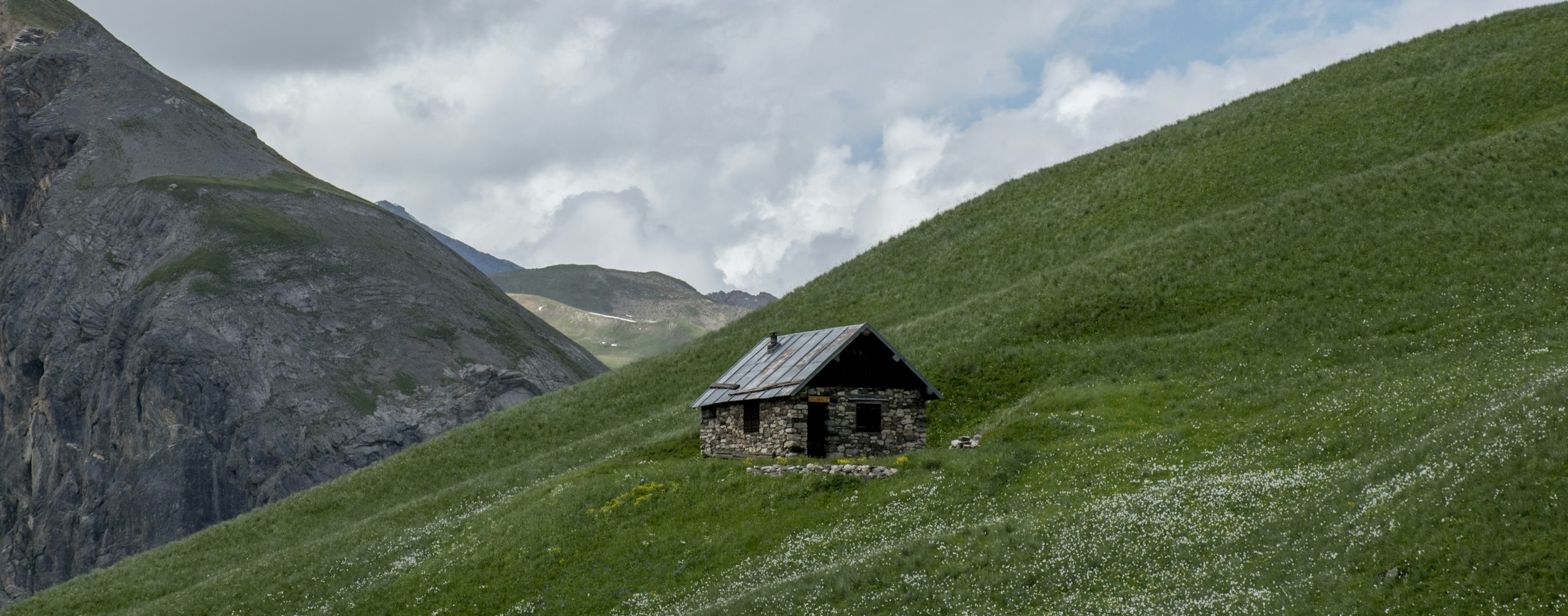 Cabane en pierre dans un alpage verdoyant
