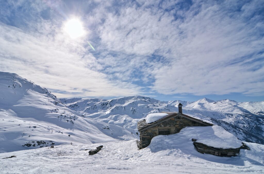 Cabane en pierre au pied des sommets enneigés, près de Valloire